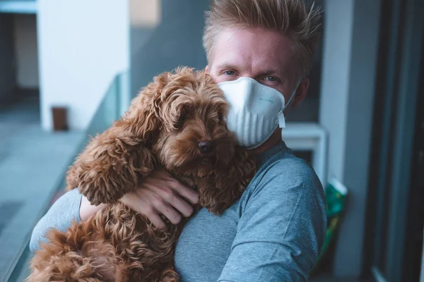 FFP3 maskesi takan bir adam yeni koronavirüsüne karşı köpek kakaolu bir maske takıyor.