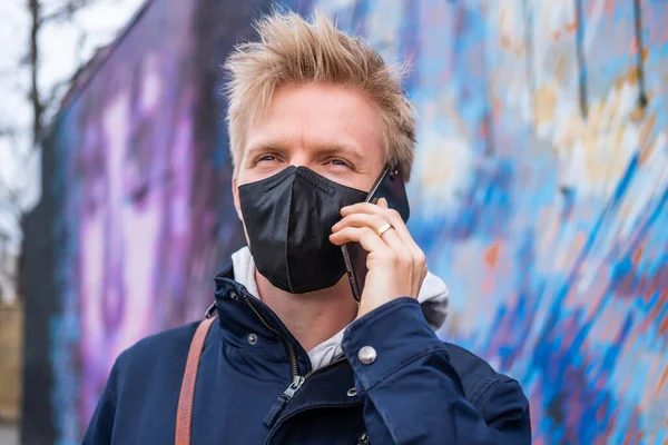 Avrupalı adam yüz maskesi takıyor. 