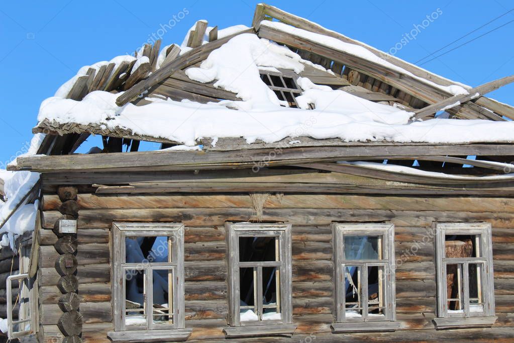 Wooden old ruined house in the village./In Russia,there are villages where abandoned houses.The houses are old,wooden logs are destroyed over time if they are left by the tenants.Winter in the North a lot of snow that helps to scrape the house.On the