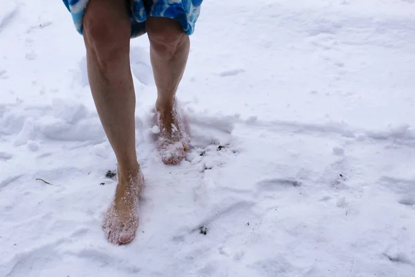 bare feet in the snow in winter / photo bare feet and snow. a woman stands on the white snow.time of year winter.it\'s cold and frosty outside.