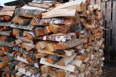 Bir kır evi / fotoğraf odunluğunun bahçesindeki kavak ağacı ve huş ağacı yığını. Huş ağacından ve kavak ağacından yapılmış ahşap. Hepsi birbirinin üzerine düzgünce istiflenmiş. Kırsal alandaki evin bahçesinde..