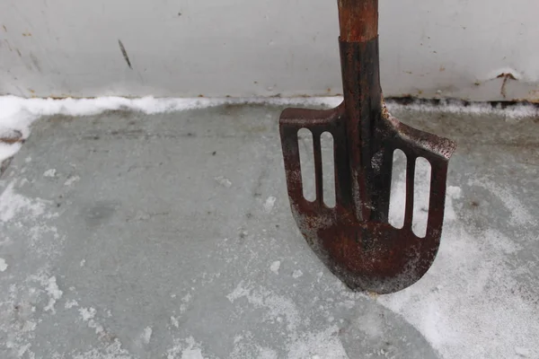 シャベルは穴のある金属で 氷の上に立っているシャベルの氷 写真です 穴のある工具 金属は錆びています 木製のハンドル — ストック写真