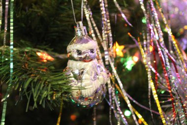 Parlak süslemeleri olan Noel ağacı, yeni yılda Noel ağacında oyuncaklar. Yeşil iğneli dallar. Takı takıyorlar. farklı parlak çelenkler ve oyuncaklar.