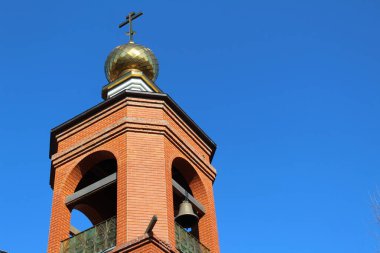 Kilisenin Altın Kubbesi 'nin çan kulesi Ortodoks Kilisesi' nin fotoğrafı. Tepesinde haçlı bir Altın Kubbe var. Çan kulede asılı..