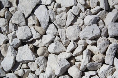 Beyaz kireçtaşı taşlarından oluşan küçük beyaz taşlardan oluşan bir duvarın arka planı. Duvar ya da zemin yapıyorlar..