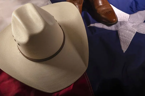 Texas cowboy hat resting a top  the Lone Star flag of Texas