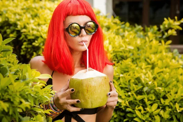 Dziewczyna z czerwone włosy pić sok zimny kokos. — Zdjęcie stockowe