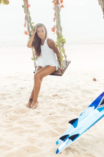 Seksi sörfçü kız salıncak tropikal plaj üzerinde. — Stok fotoğraf