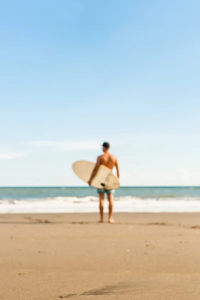 Schöner Mann mit Surfbrett vor Ort. — Stockfoto