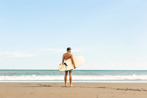 Schöner Mann mit Surfbrett vor Ort. — Stockfoto