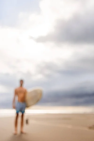 Schöner Mann mit Surfbrett vor Ort. — Stockfoto