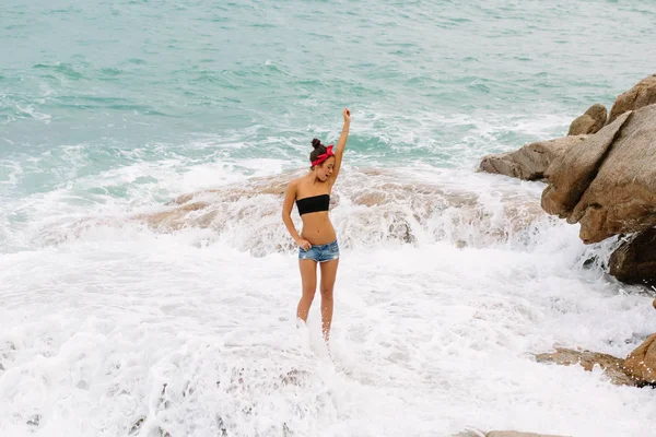 Menina bonita em shorts curtos andar em grandes pedras . — Fotografia de Stock