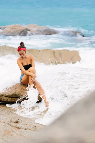 Hermosa chica en pantalones cortos sentarse en piedras grandes . —  Fotos de Stock