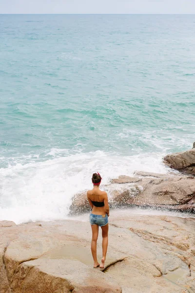 Hermosa chica en pantalones cortos caminar sobre piedras grandes . —  Fotos de Stock