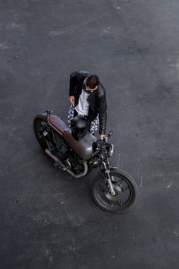 Top view to brutal man with cafe racer custom motorbike. clipart