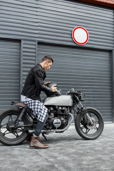 Brutale uomo sedersi su cafe racer moto personalizzato . — Foto Stock