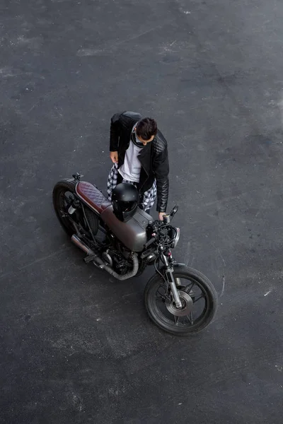 Vista superior al hombre brutal con la motocicleta personalizada del corredor de la cafetería . — Foto de Stock