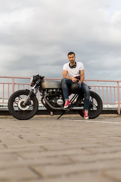 Brutale man zitten op café racer aangepaste motor. — Stockfoto