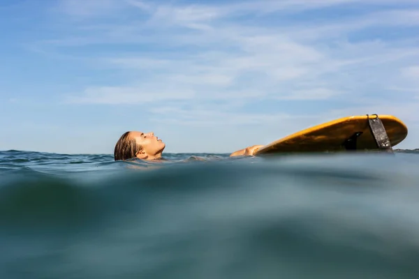 Egy gyönyörű sportos lány szörfözés az óceánban. — Stock Fotó