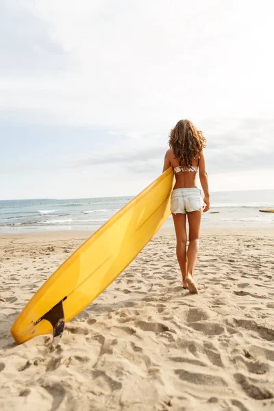 Bella ragazza surfista sportiva in spiaggia . — Foto Stock