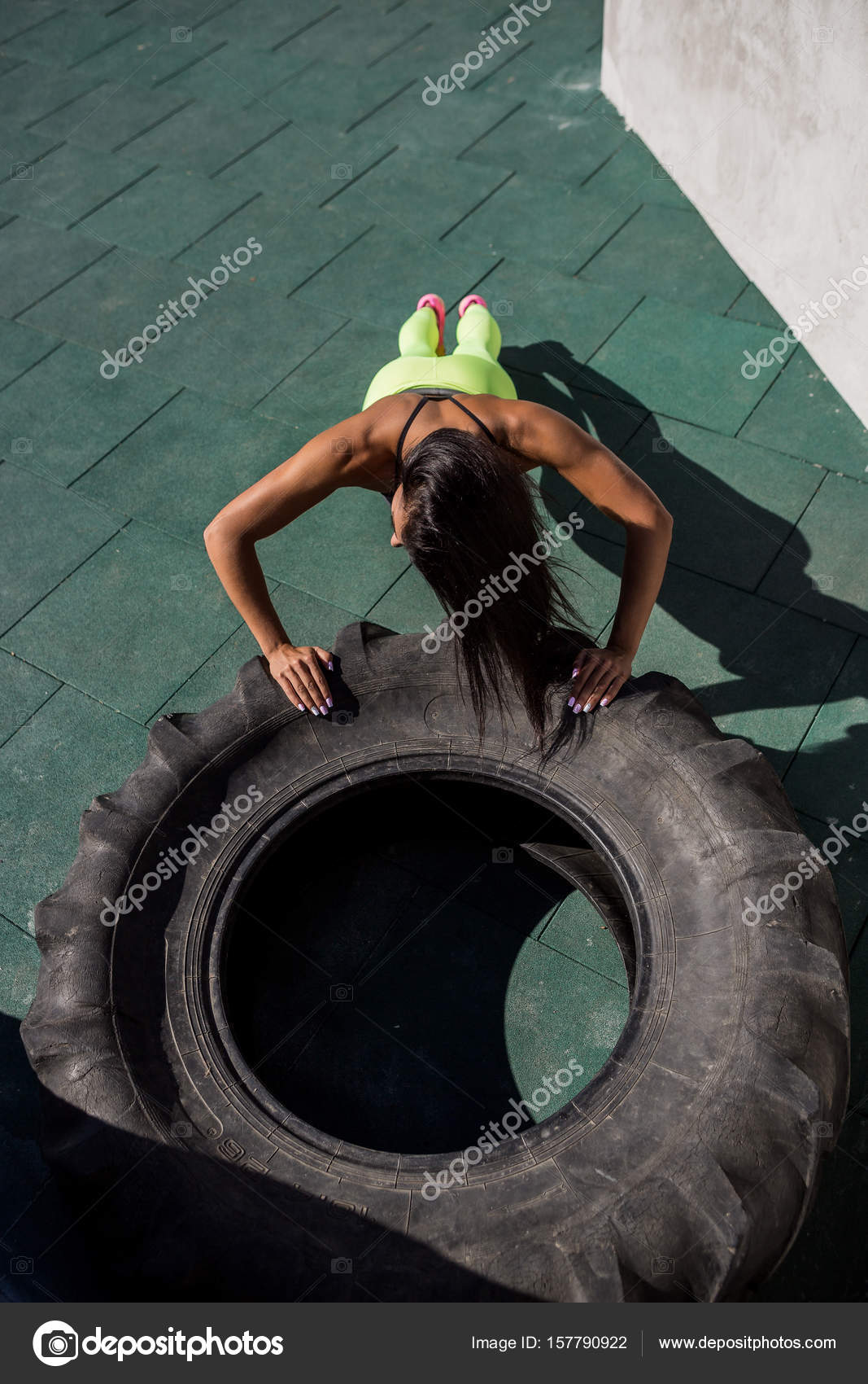 Beautiful Young Woman With Long Legs In Bright Sexy Shorts With Pretty  Athlete Muscular Body Rest In Big Heavy Tire. Crossfit Training Urban Area  Street Gym City Exercise Routine Healthy Lifestyle. Stock