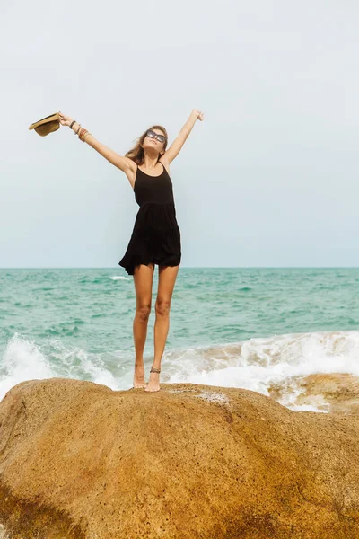 Nettes Mädchen im schwarzen Sommerkleid an großen Steinen. — Stockfoto