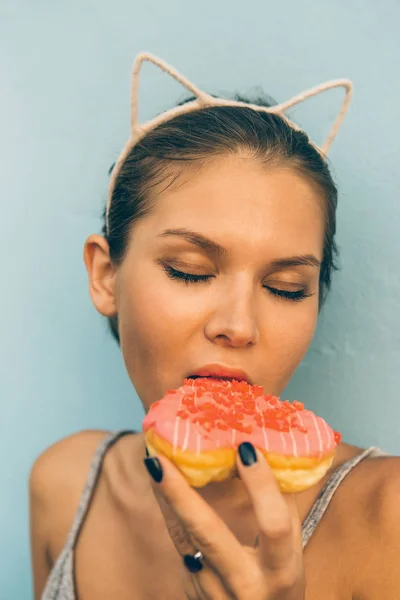 Sexy bruna signora mangiare dolce cuore a forma di ciambella . — Foto Stock