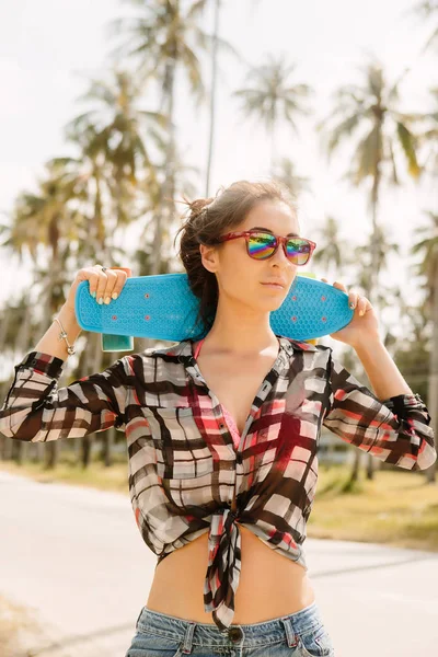 Mooi meisje met skateboard op de weg. — Stockfoto