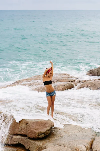 Schöne Mädchen in kurzen Shorts gehen auf großen Steinen. — Stockfoto