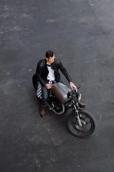 Vista superior al hombre brutal con la motocicleta personalizada del corredor de la cafetería . —  Fotos de Stock