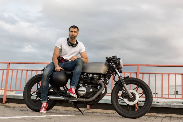 Brutální muž sedí na vlastní motorce café racer. — Stock fotografie