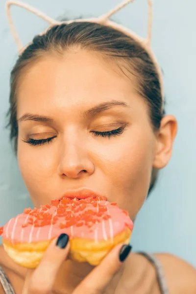 Wanita berambut cokelat seksi makan donat berbentuk hati manis . — Stok Foto