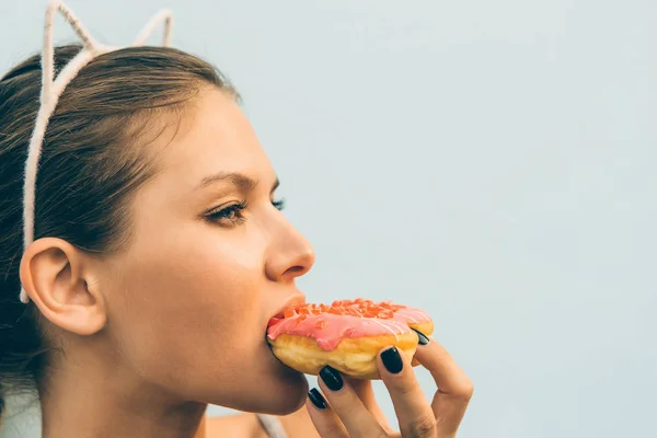 Seksowna brunetka Pani jeść słodkie pączki w kształcie serca. — Zdjęcie stockowe