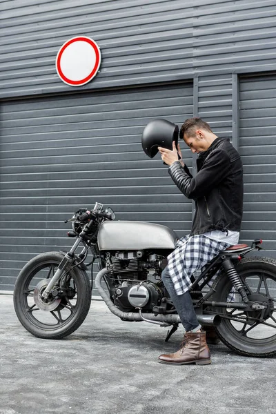 Brutální muž sedí na vlastní motorce café racer. — Stock fotografie