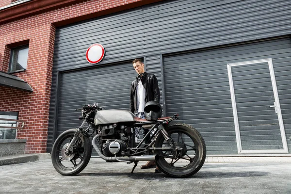 Brutale uomo vicino al suo caffè racer moto personalizzato . — Foto Stock