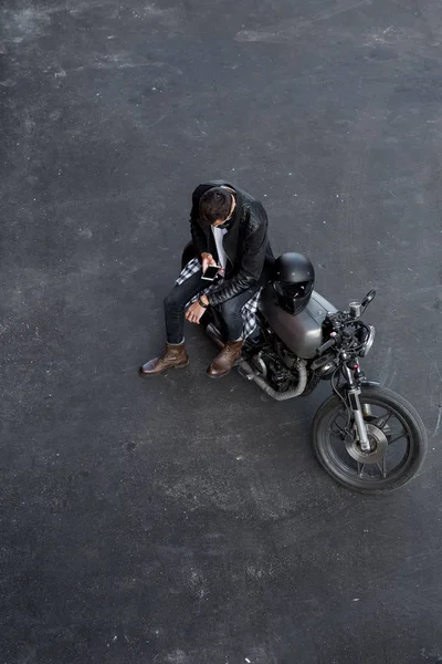 Vista superior al hombre brutal con la motocicleta personalizada del corredor de la cafetería . — Foto de Stock