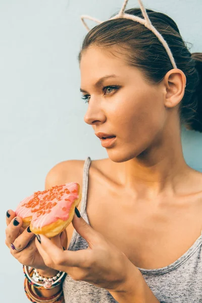 Seksowna brunetka Pani jeść słodkie pączki w kształcie serca. — Zdjęcie stockowe