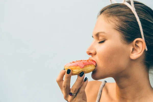 Sexy morena senhora comer doce coração em forma de donut . — Fotografia de Stock