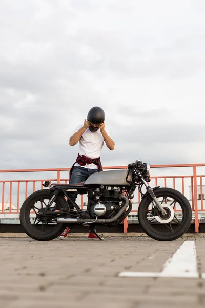 Brutaler Mann in der Nähe seines Café-Racers. — Stockfoto