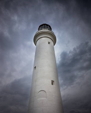 Fırtınalı bulutlar ile uzun boylu dramatik deniz feneri
