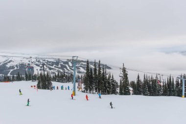 Kayakçı ve snowboard düşkünleri Whistler Blackcomb yamaç aşağı gidiyor 