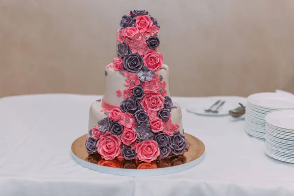 美丽精致的三层的婚礼蛋糕装饰着鲜花玫瑰粉红色米色紫罗兰色 — 图库照片