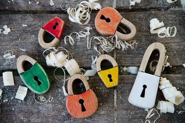 Handgemaakte hangslot houten speelgoed. Op de houten achtergrond met houten schaafsel. Mooie sleutelgat in de vorm van harten en klassieke sleutelgat — Stockfoto