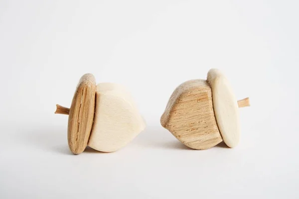 Wooden hand-made acorn toy for children isolated on the white background with shadow reflection. Wooden acorn for playing with kids. Natural typical wooden toy in the shape of cute acorn — Stockfoto