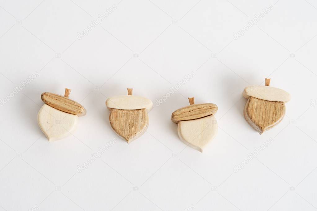 Wooden hand-made acorn toy for children isolated on the white background with shadow reflection. Wooden acorn for playing with kids. Natural typical wooden toy in the shape of cute acorn