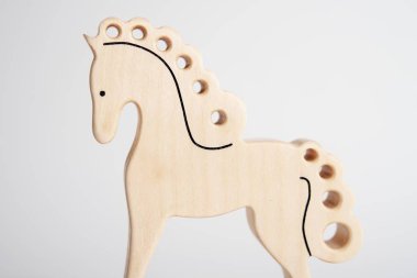 Beyaz arka planda gölge yansıması ile izole çocuklar için tahta at el yapımı oyuncak. Çocuklarla oynamak için ahşap meşe palamudu. Küçük at şeklinde doğal tipik ahşap oyuncak