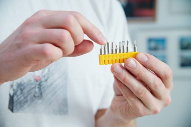 Adam yeni tornavida seti elinde tutar. Beyaz deri