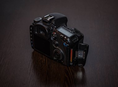 Bir dijital Slr fotoğraf makinesi bir masada yatıyor