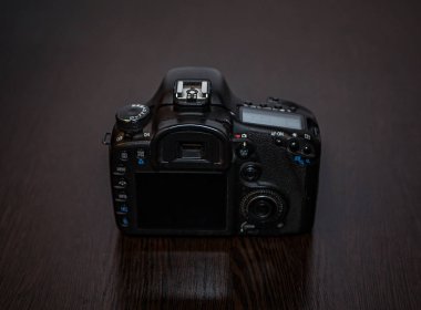 Bir dijital Slr fotoğraf makinesi bir masada yatıyor