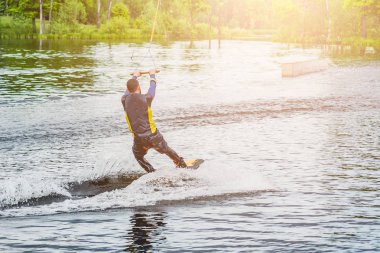 güneşli yaz günü Nehri üzerinde bir gemide Wakeboarder rides